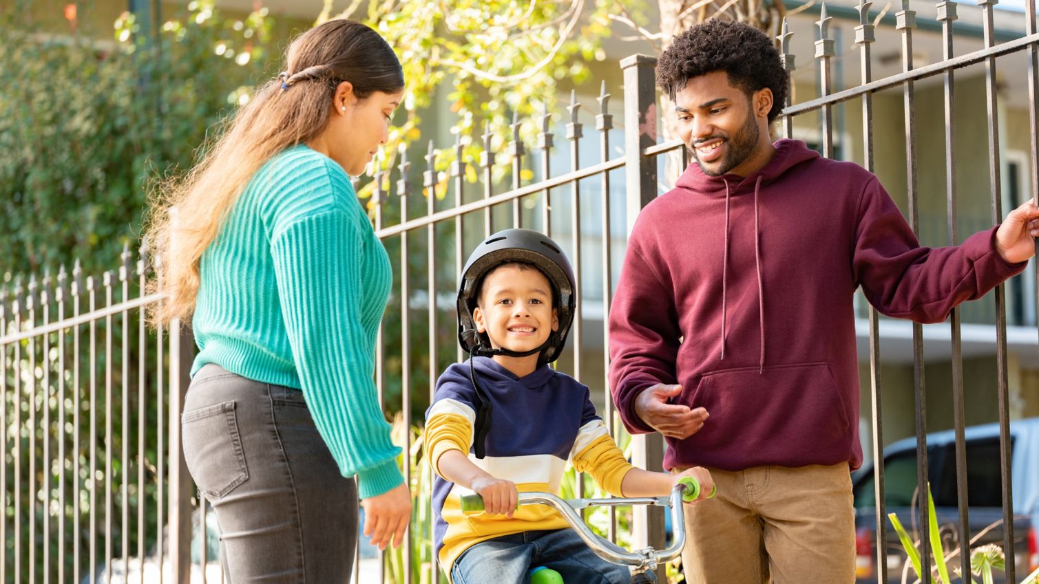 Family help child learn to ride a bike