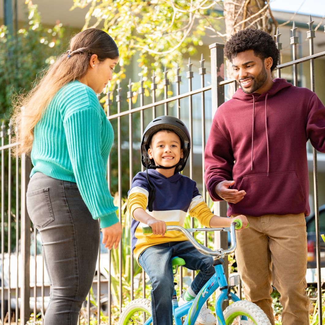 Family help child learn to ride a bike