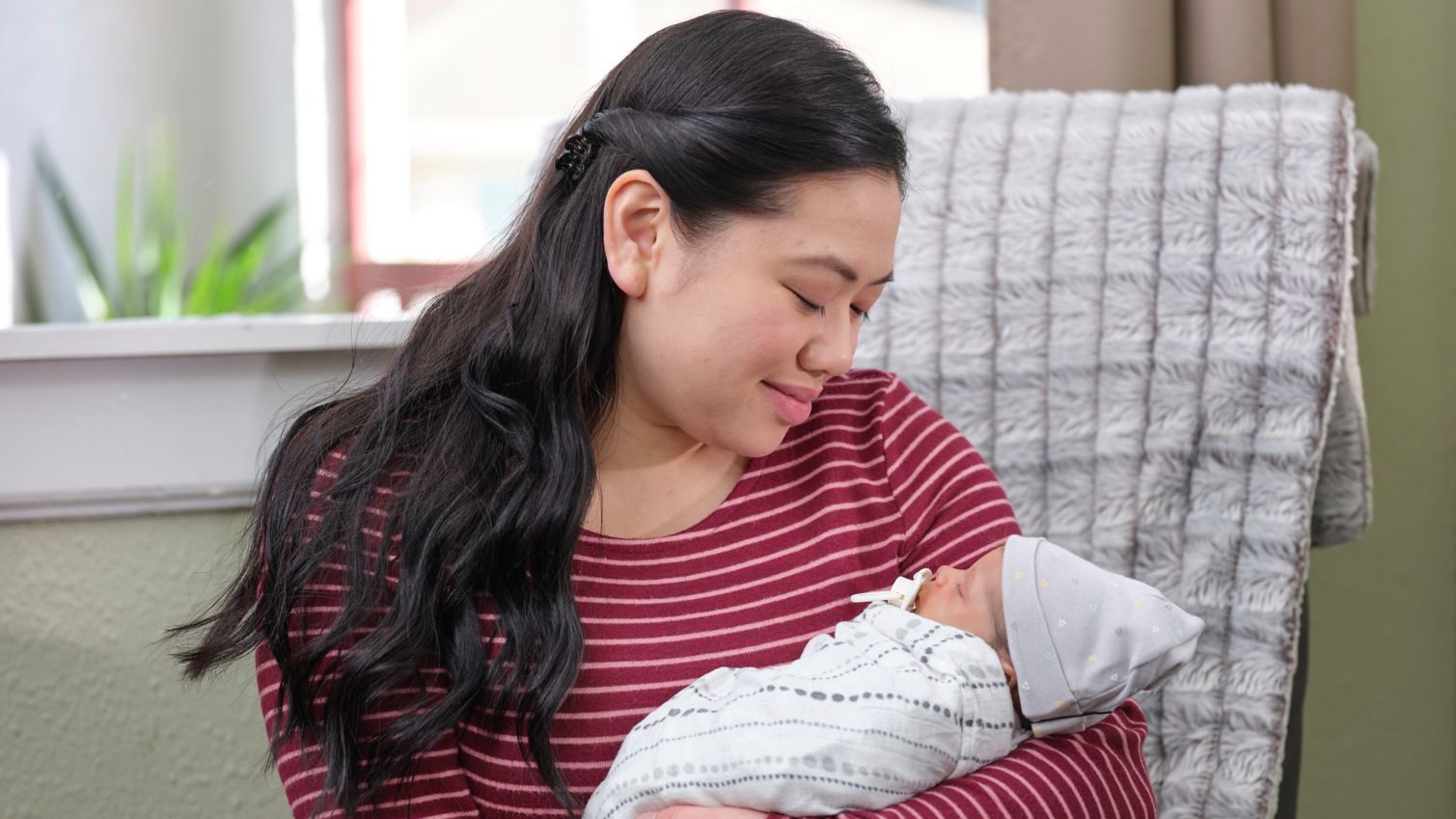 Mom holds her newborn baby at home