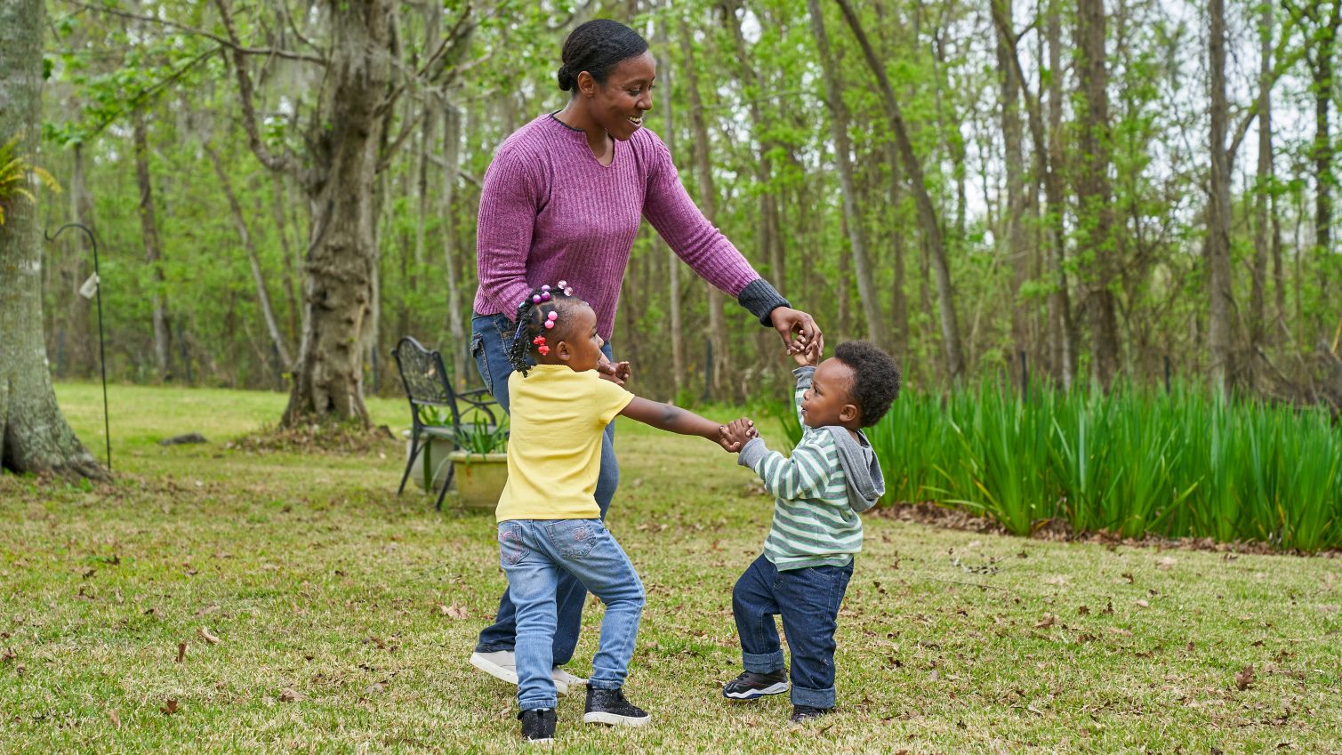 Woman with two small children play outdoors