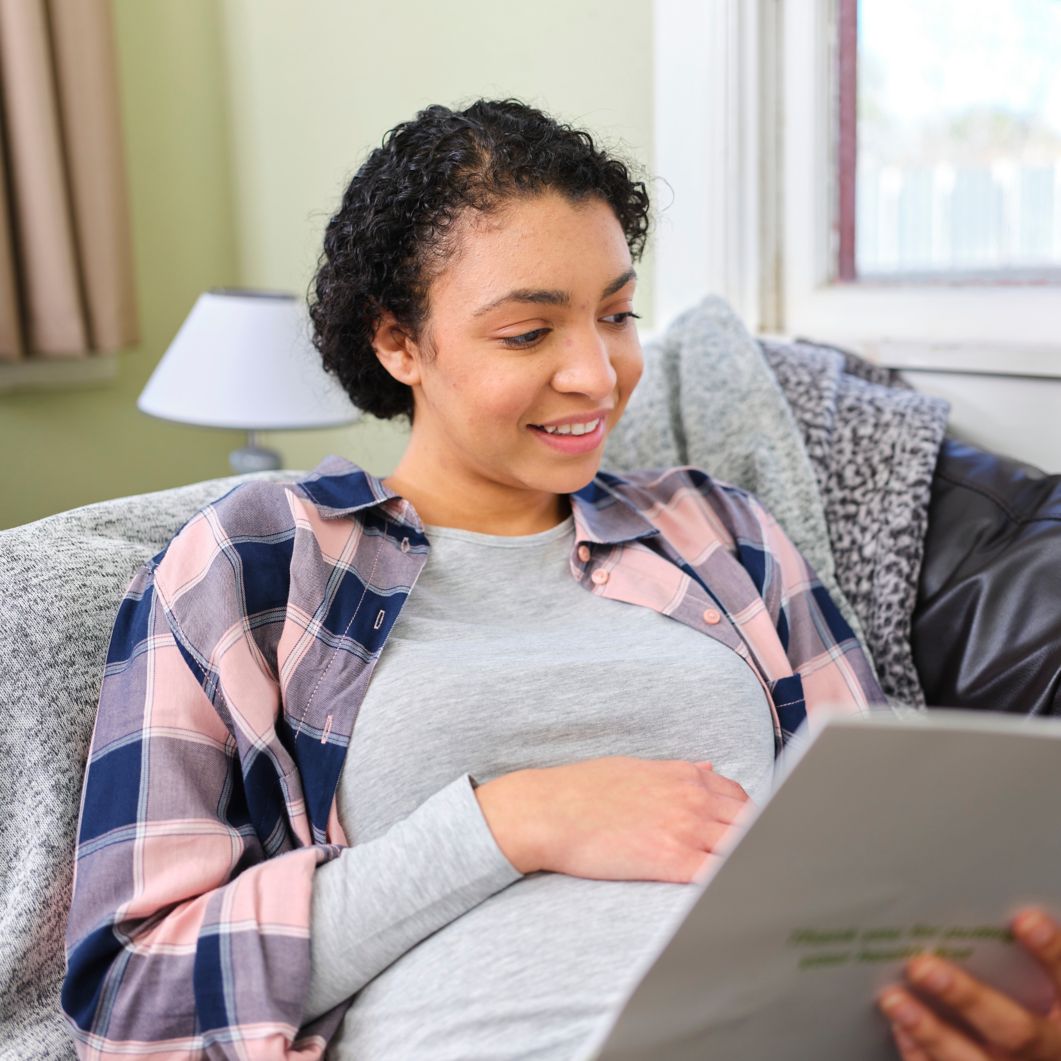 Pregnant woman reads paperwork