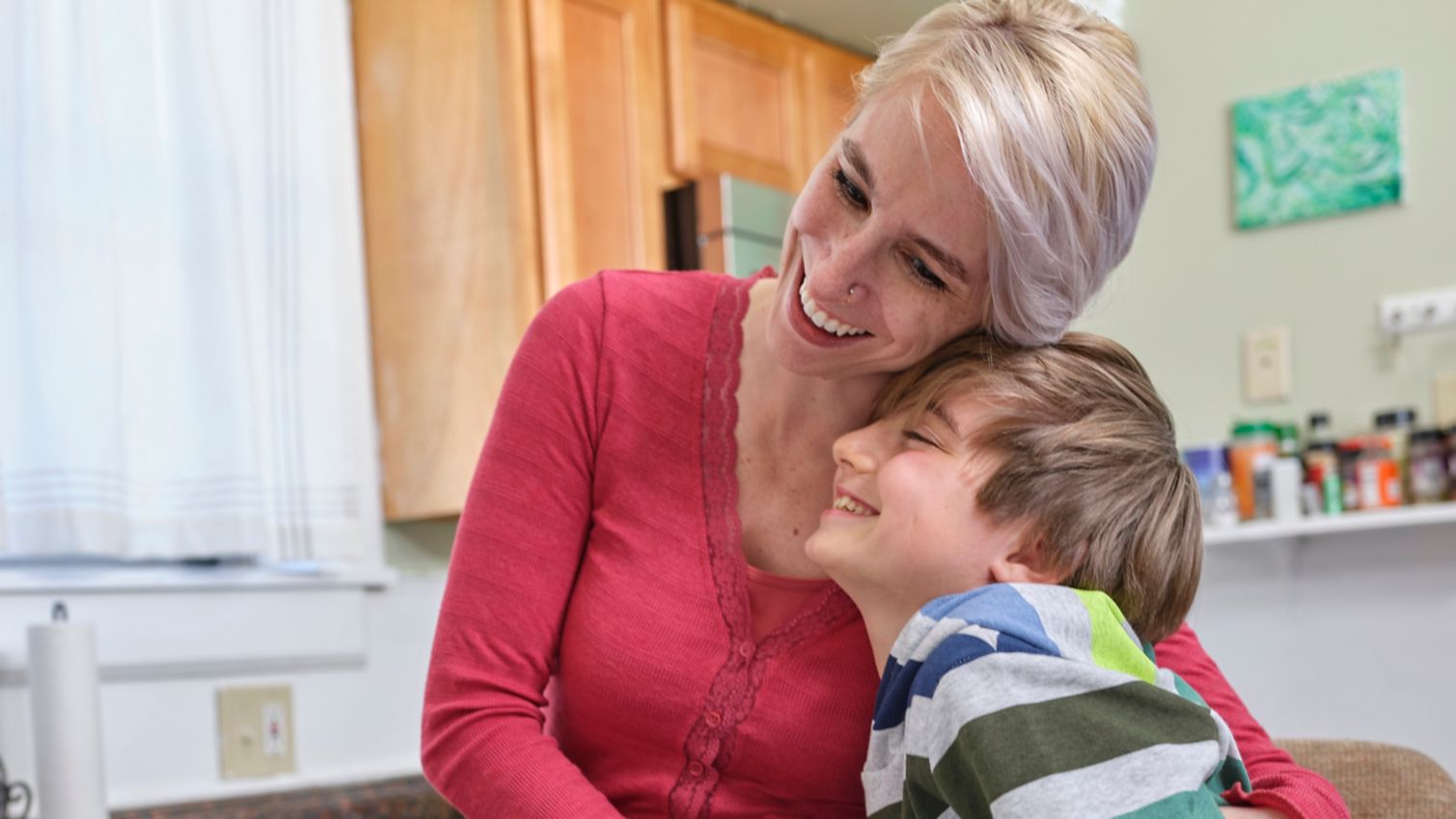 Mom and son hugging in kitchen