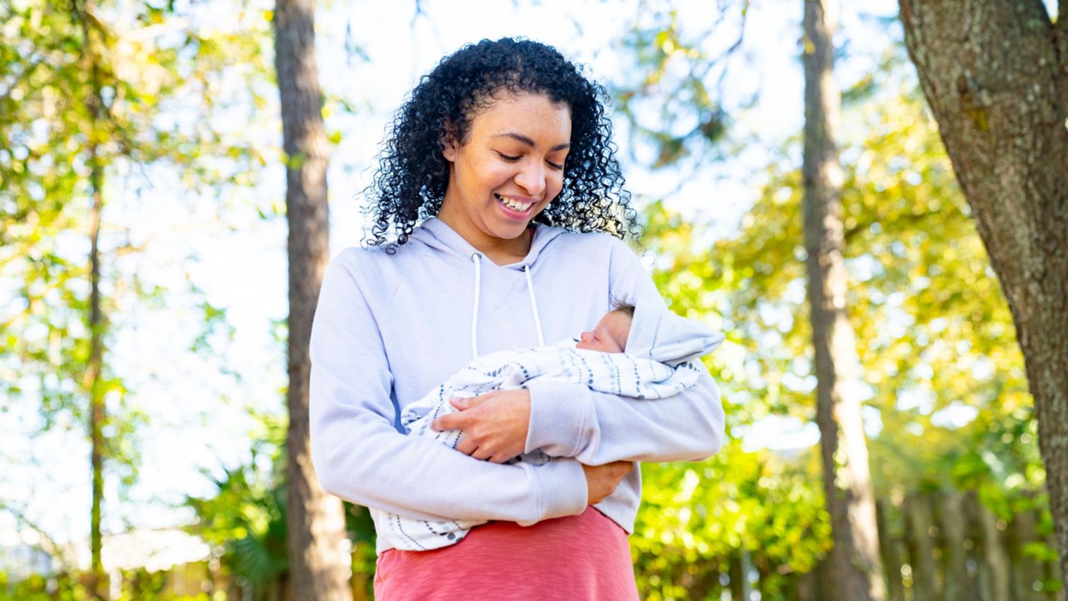 A smiling mouther holding her baby