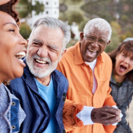 Group of four diverse happy seniors laughing together