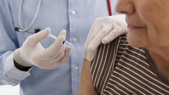 Woman at doctor’s office receiving flu shot.