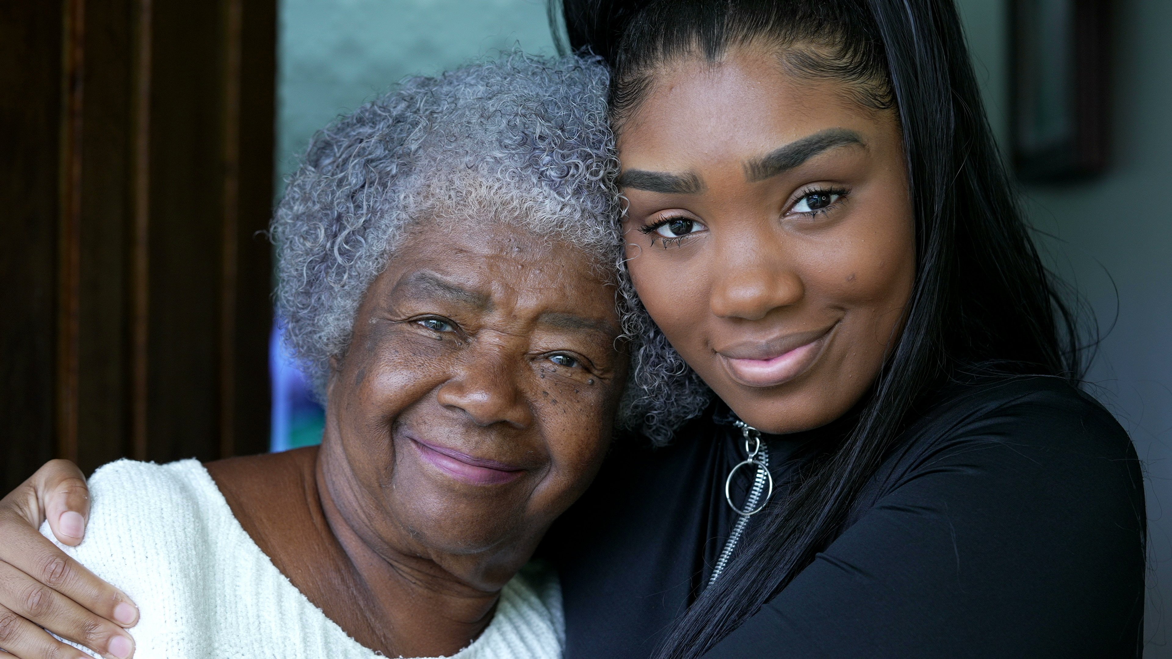 A teen granddaughter embracing grandmother a black girl embraces grandparent