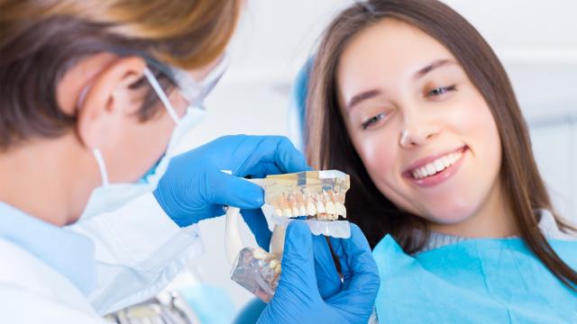 Dentist teaching patient to use night guard.