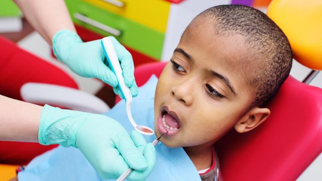 A young child has their teeth examined.