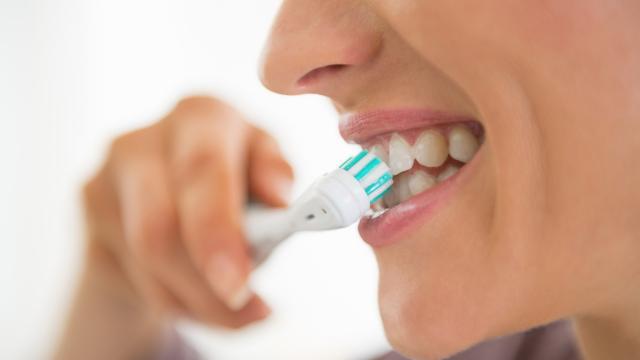 Woman using an electric toothbrush.