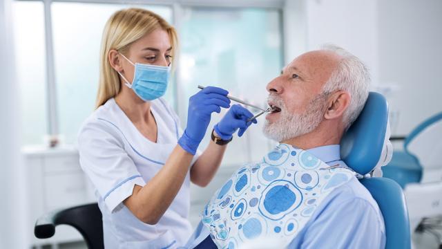 A dentist checks a senior’s teeth.