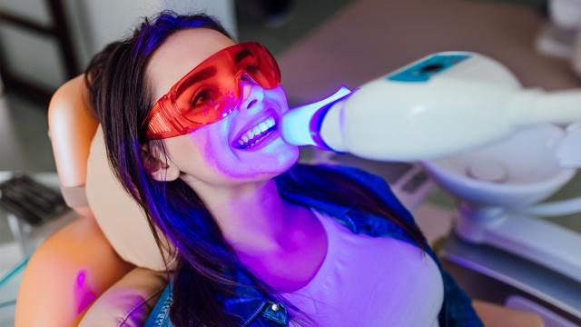 A woman has her teeth whitened at a dental office.