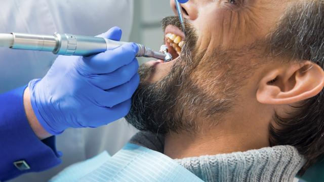 Dentist cleaning a patient's teeth.
