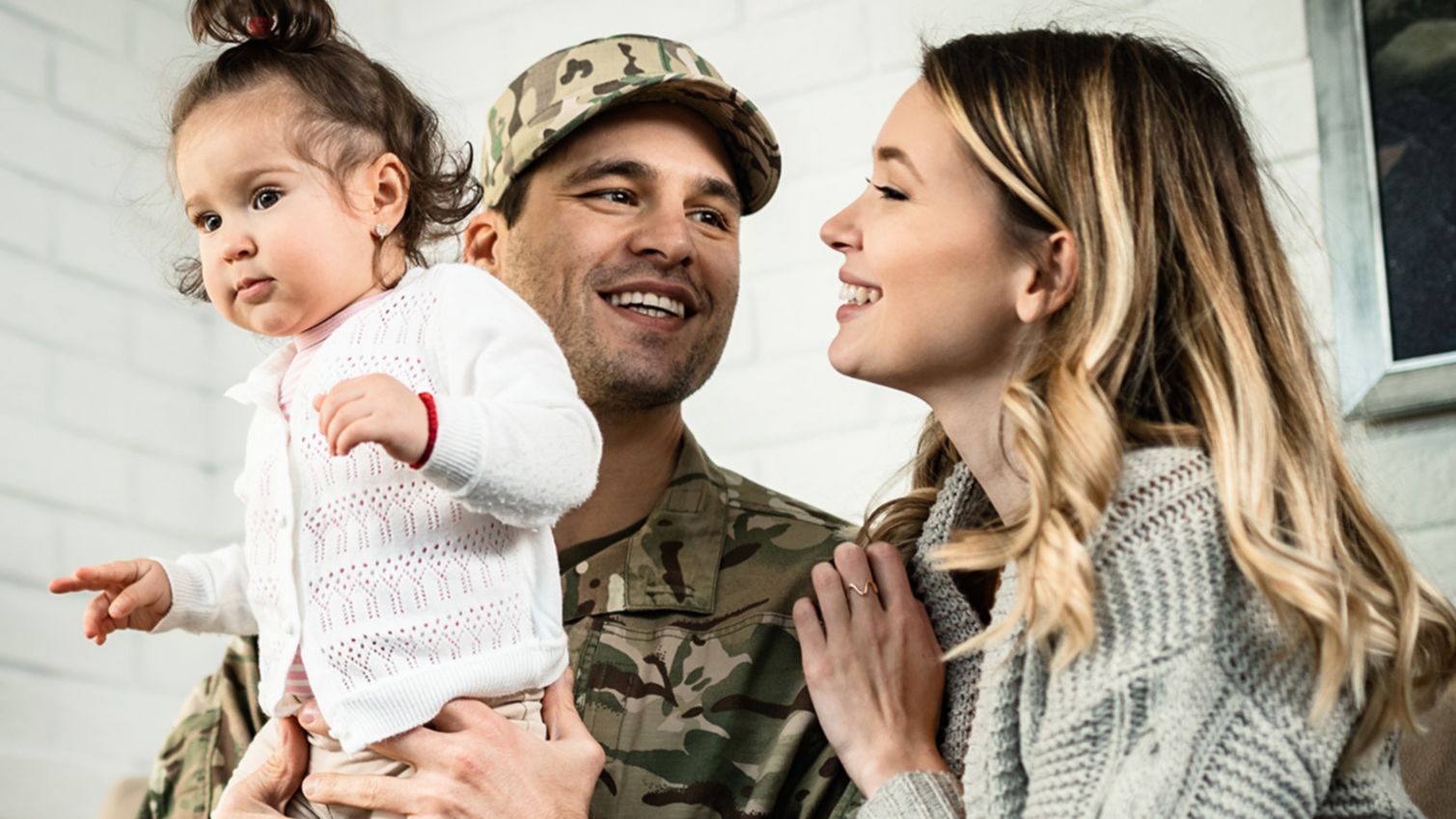 A man in a military uniform reunites with his family.