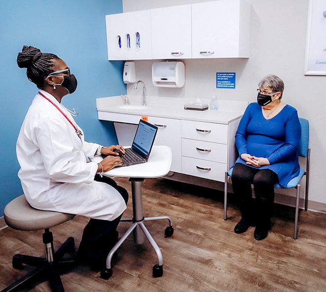 Female doctor speaking with patient and taking notes while seated in doctor's office