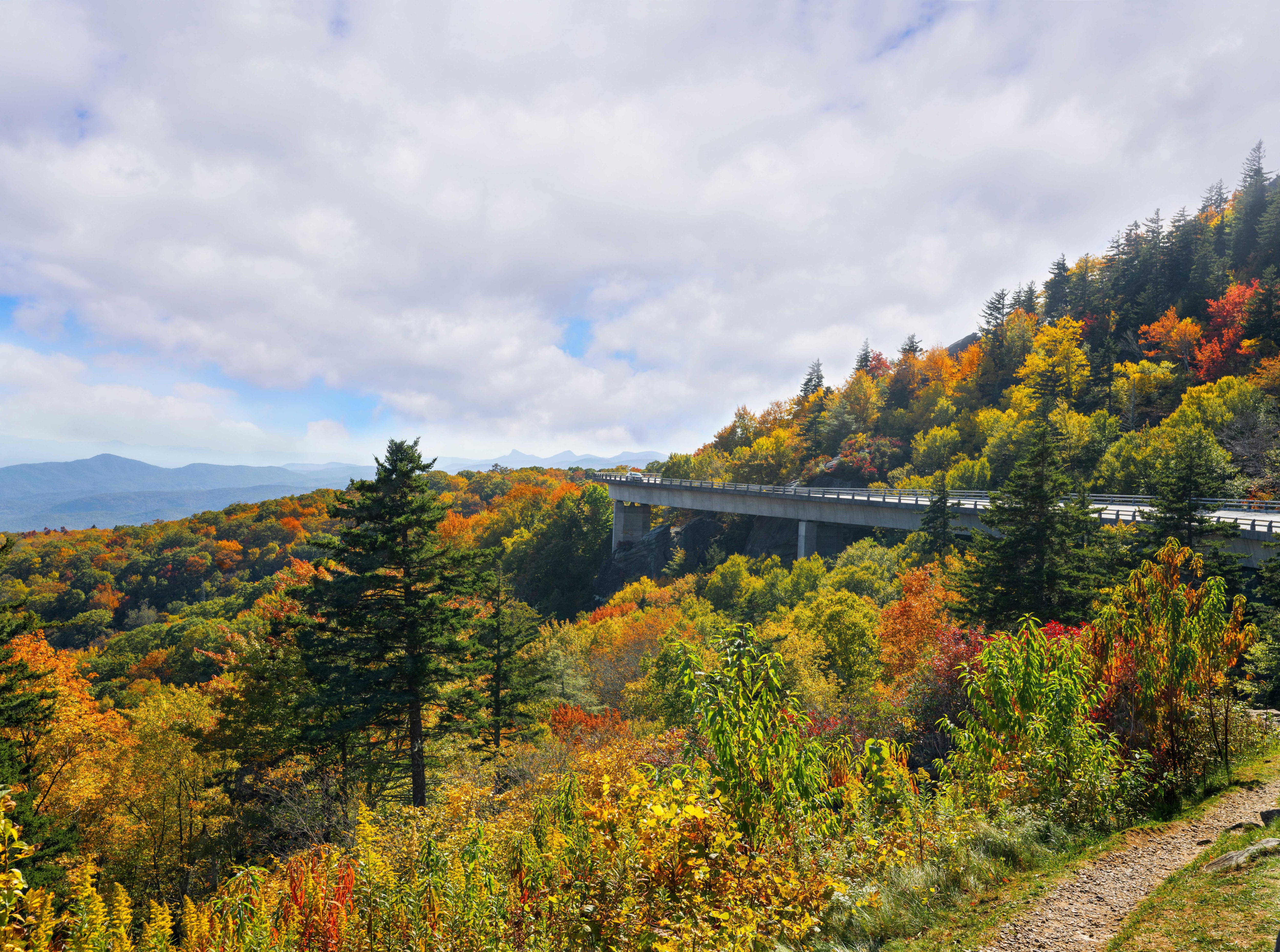 Road winding in colorful mountains. Beautiful mountain autumn  landscape. Linn Cove Viaduct, near Blowing Rock, Blue Ridge Parkway, North Carolina, USA.