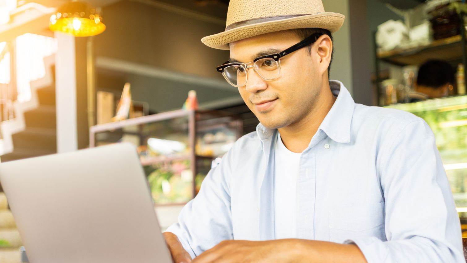 One man typing on his computer outside